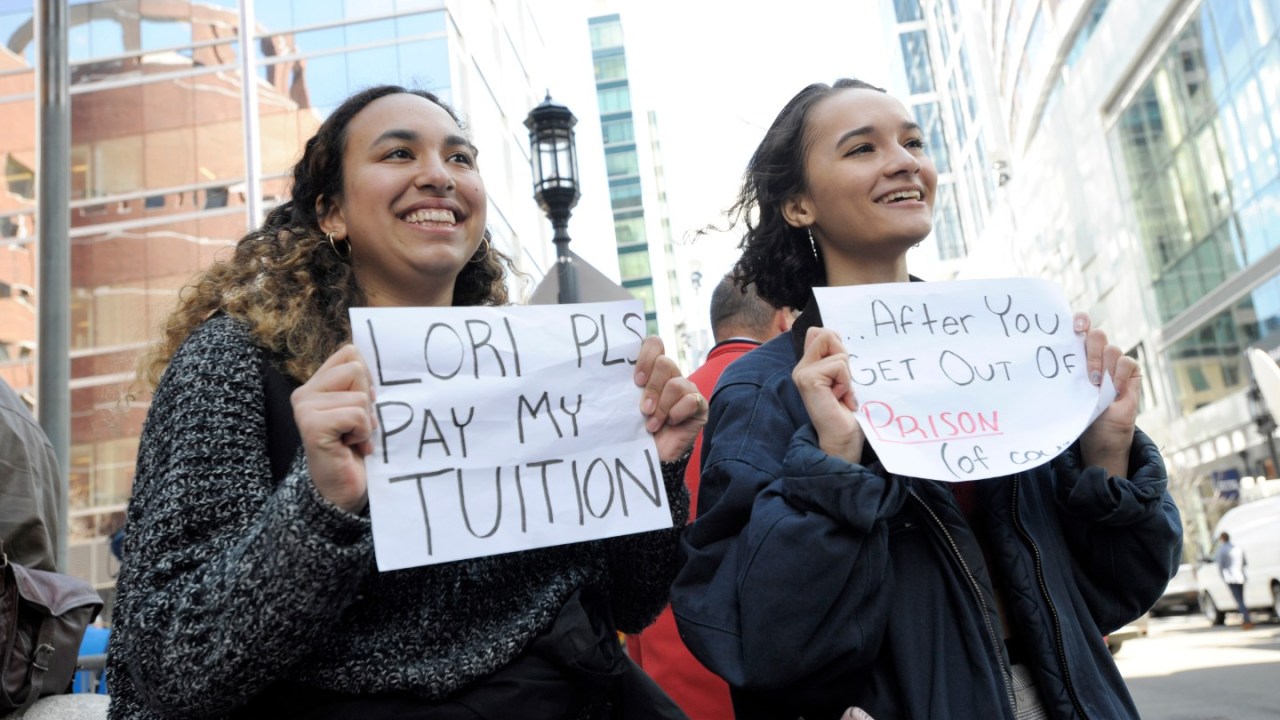 Young people hold up signs during Felicity Huffman's trial