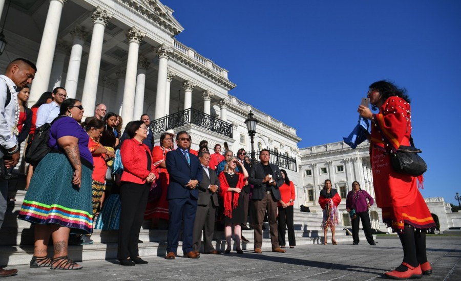 people hold a moment of silence for missing and murdered indigenous women in front of the Capitol