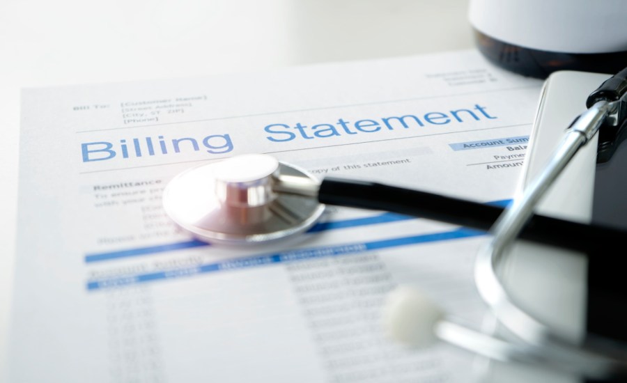 a billing statement on a table along with a stethoscope