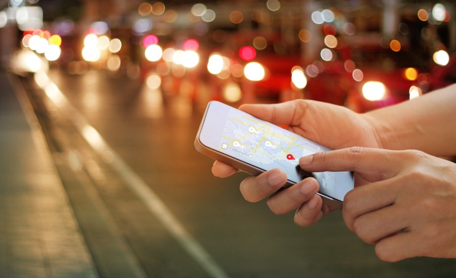 a person's hand using their smartphone's location tracking features