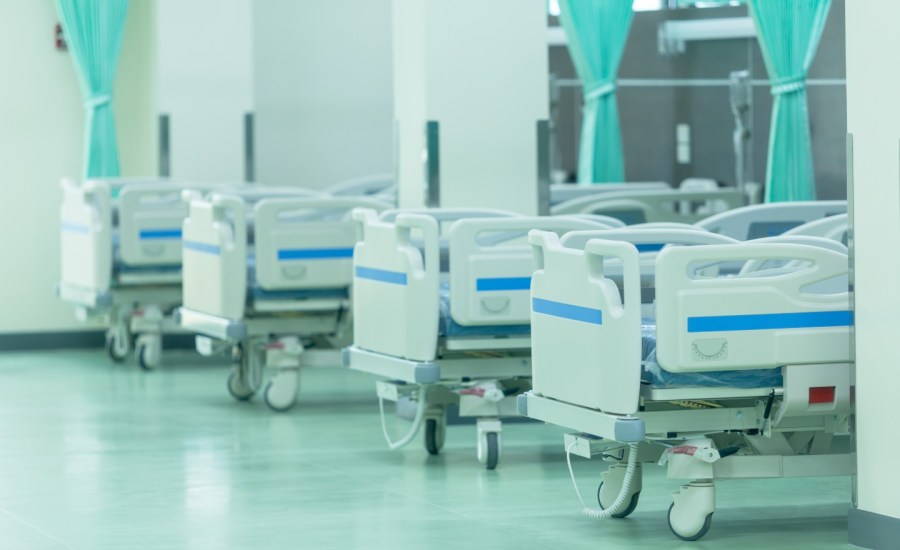 a row of empty patient beds in a hospital