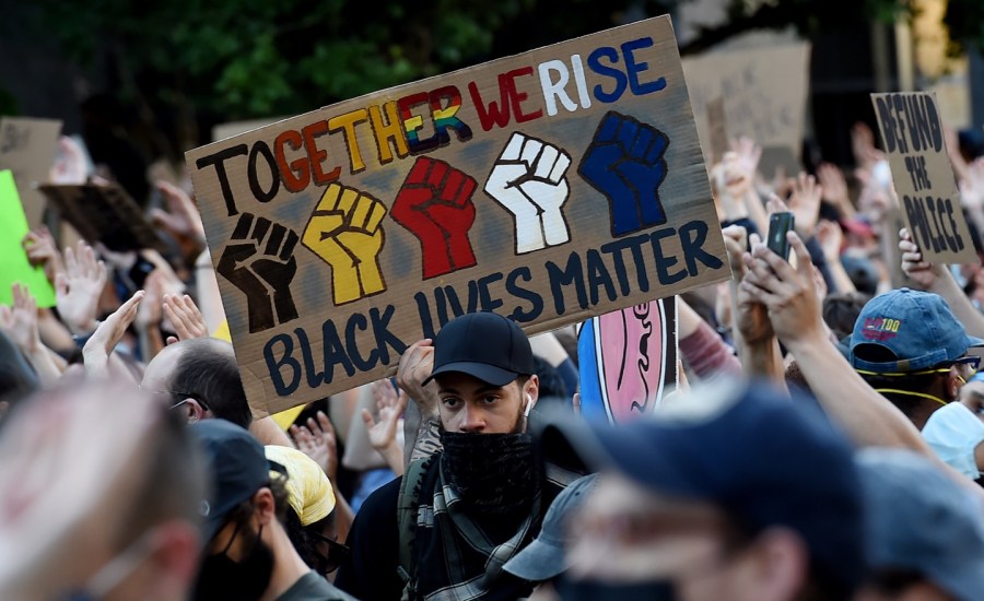 protestors in Lafayette square outside the White House in Washington DC hold signs against police brutality and systemic racism