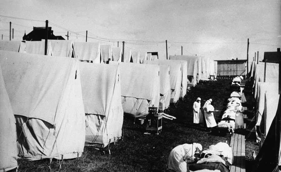 Nurses care for victims of a Spanish influenza epidemic outdoors amidst canvas tents during an outdoor fresh air cure in Lawrence, Massachusetts.