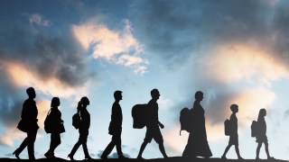 silhouettes of immigrants walking with luggage
