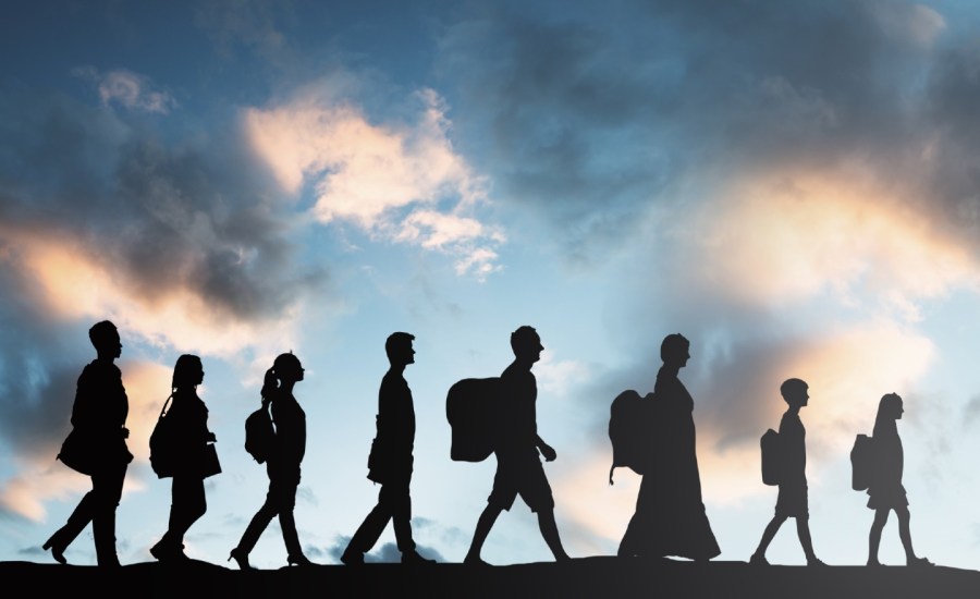 silhouettes of immigrants walking with luggage