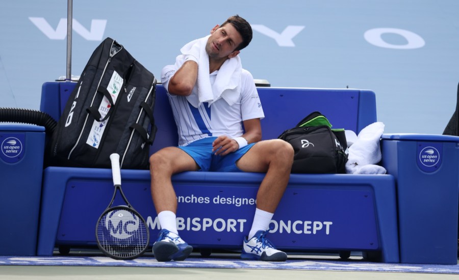 Novak Djokovic of Serbia rests between games against Jan Leonard Struff of Germany during the Western & Southern Open at the USTA Billie Jean King National Tennis Center