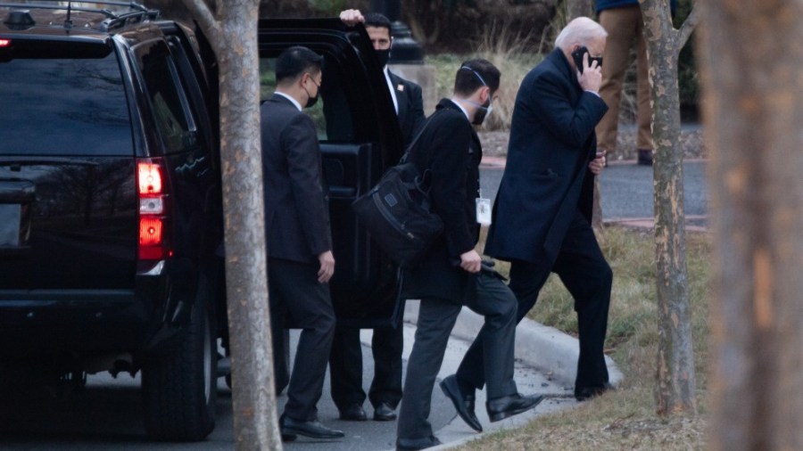 President Biden exits vehicle with staffers