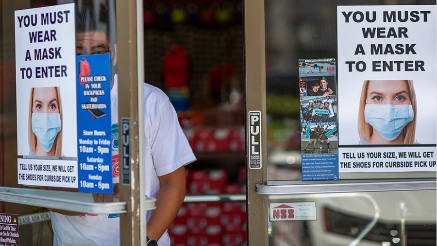 A sign telling customers that they cannot enter the store without a mask