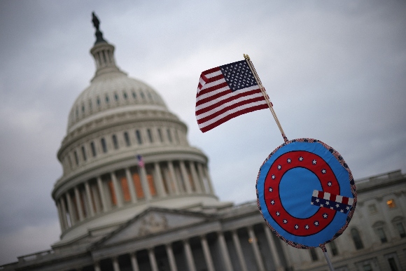 Supporters of U.S. President Donald Trump fly a U.S. flag with a symbol from the group QAnon as they gather outside the U.S. Capitol January 06, 2021 in Washington, DC.