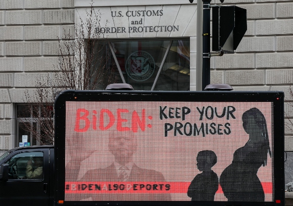 An L.E.D. truck displaying messages expressing concern over the continuing mass deportations of Black immigrants drives past the office of U.S. Customs and Border Protection