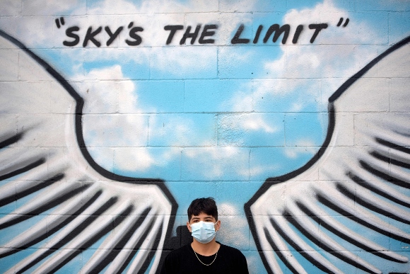 Marlon II Gonzalez waits for his brother Akileze King Gonzalez to pose at a mural in downtown Houston, Texas 