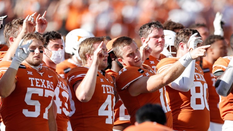 University of Texas football players stand while 'The Eyes of Texas' is played after a game