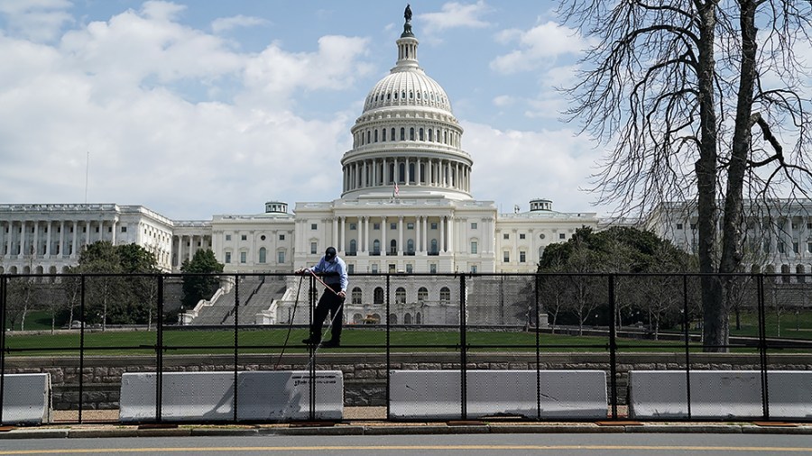 An Architect of the Capitol Worker is seen on the inner fence