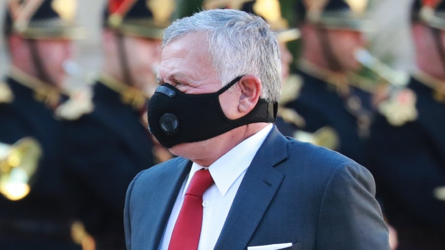 Jordanian King Abdullah II walks past the honor guard as he arrives at the Elysee Palace in Paris for a meeting with the French president