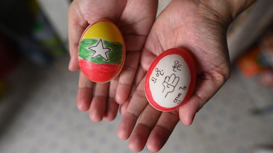 A protester in Myanmar holds two decorated Easter eggs