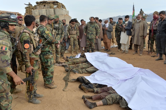 Afgan security forces gather around the bodies of Taliban militants killed during fighting and air airstrikes