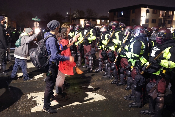 Demonstrators face off with police officers outside of the Brooklyn Center police station