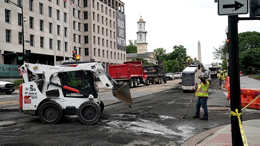 Workers repave Black Lives Matter Plaza on May 10 in Washington, D.C.