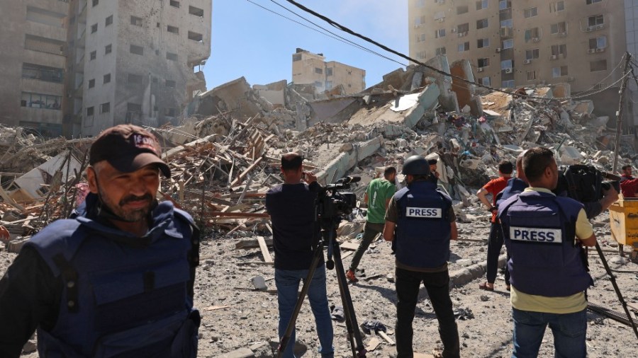 Palestinian journalists cover the destroyed Jala Tower, which was housing international press offices