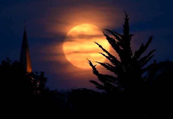 The moon is seen rising above the village of Brixworth on May 07, 2020 in Brixworth, England