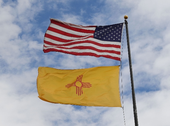 The US and New Mexico flags fly