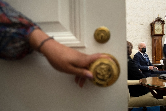 US Vice President Kamala Harris listens while US President Joe Biden speaks to the press