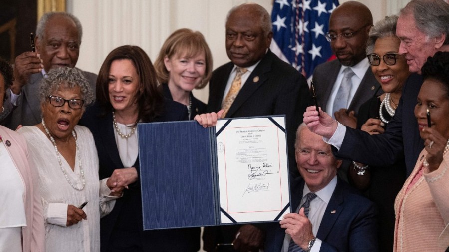 President Biden holds the newly signed Juneteenth National Independence Day Act in the East Room of the White House