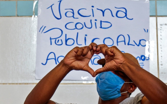 A homeless man makes the shape of a heart with his hands after being inoculated with the CoronaVac vaccine against COVID-19 during an immunization campaign for people on the streets in Sao Paulo, Brazil