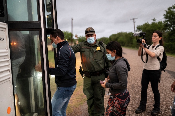 Migrants make their onto a bus after being apprehended near the border between Mexico and the United States in Del Rio, Texas