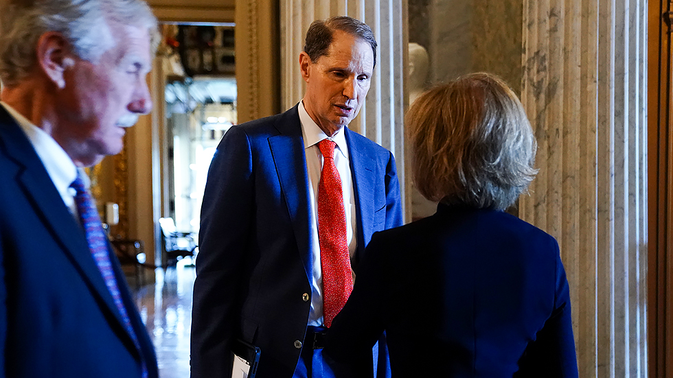 Sen. Ron Wyden (D-Ore.) speaks to Sen. Tina Smith (D-Minn.) on June 15