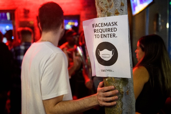 Face mask signage is displayed outside the Trunks bar