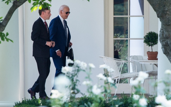 US President Joe Biden walks with National Security Advisor Jake Sullivan (L) to the Oval Office