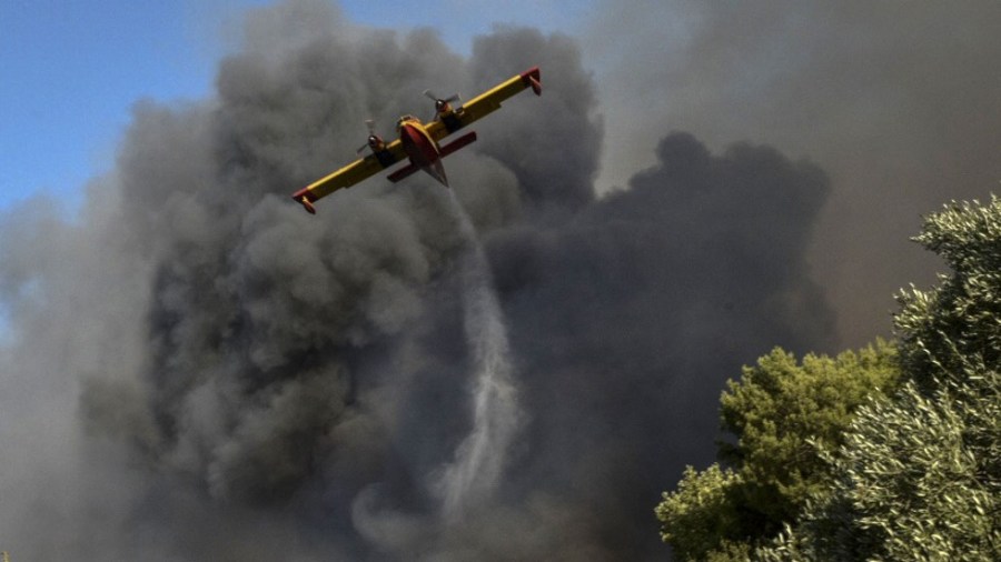 A plane drops water on a wildfire near Patras, Greece