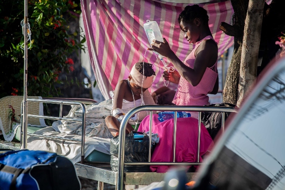 A boy is tended to outside Les Cayes General Hospital after a 7.2-magnitude earthquake