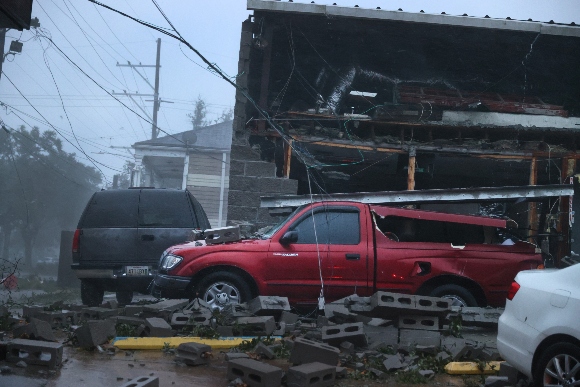 Vehicles are damaged after the front of a building collapsed during Hurricane Ida on August 29, 2021 in New Orleans