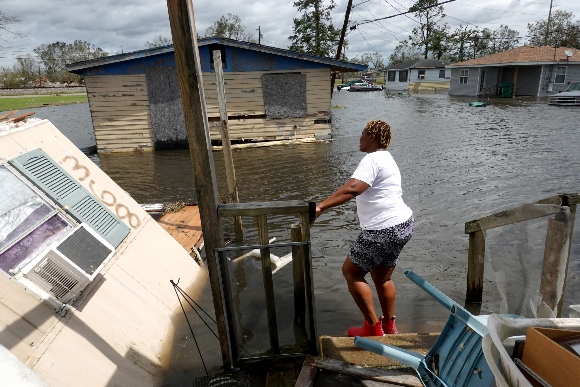 Dina Lewis rescues items from her home after it was destroyed by Hurricane Ida