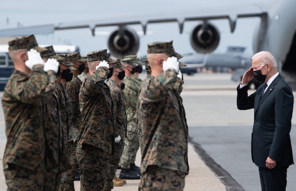 President Joe Biden salutes members of the military transfer team after attending a dignified transfer of the 13 members of the US military killed in Afghanistan