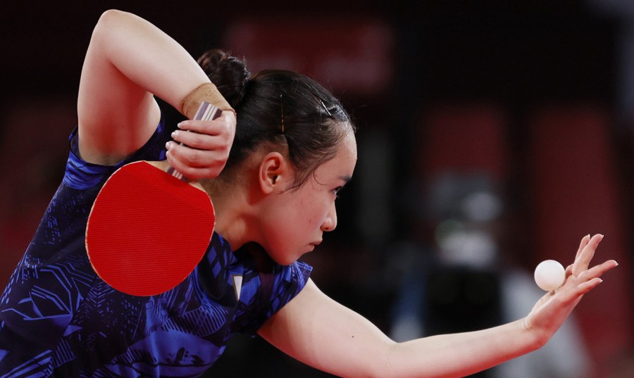 Ito Mima prepares to serve a table tennis ball with a red paddle