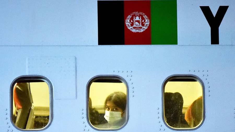 A young child looks out the window of a plane as they are being evacuated out of Kabul.