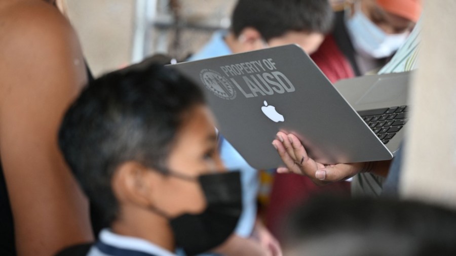 An administrator confirms student health check data on a laptop on the first day of the school year at Grant Elementary School, in Los Angeles