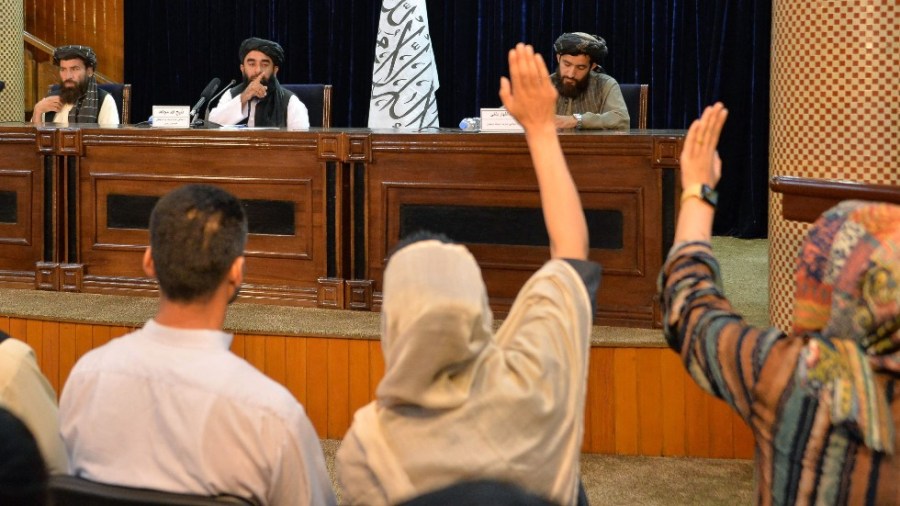 Taliban spokesperson Zabihullah Mujahid calls on journalists raising their hands to ask a question during a press conference in Kabul