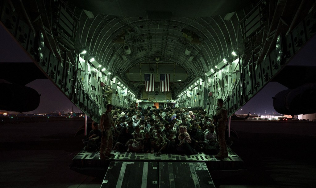 A U.S. Air Force air crew assigned assists evacuees huddled in a plane