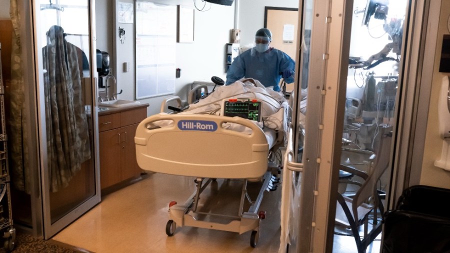 Medical staff move a COVID-19 patient from the emergency room into the COVID-19 Intensive Care Unit