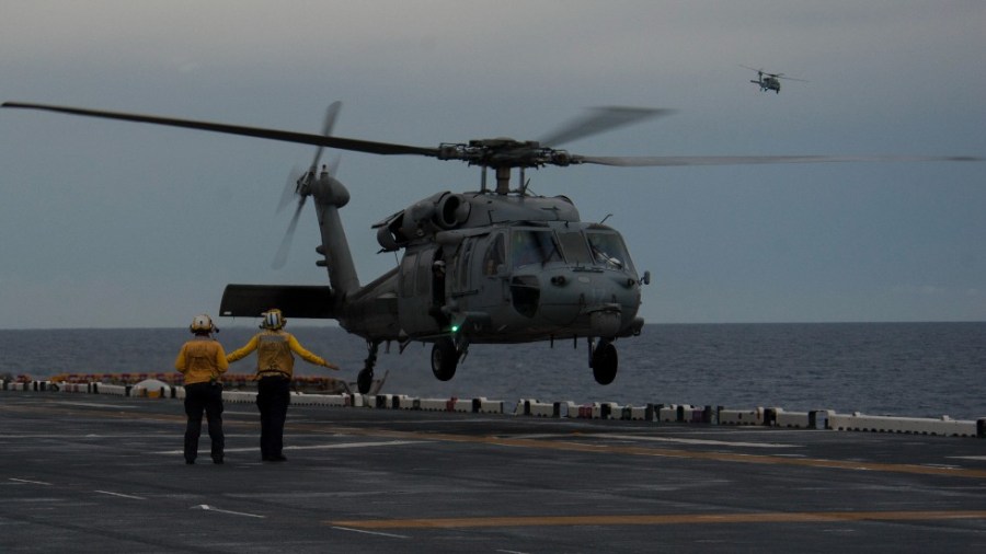 Sailors signal an MH-60S helicopter