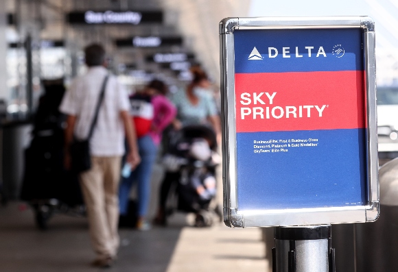 Travelers gather outside the Delta Air Lines departures level at Los Angeles International Airport