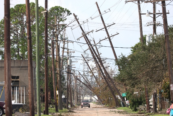 Utility poles lean over a street following Hurricane Ida