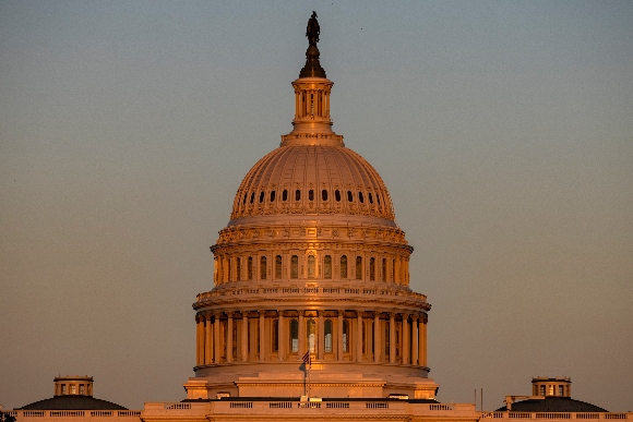 The U.S. Capitol building is illuminated by the setting sun