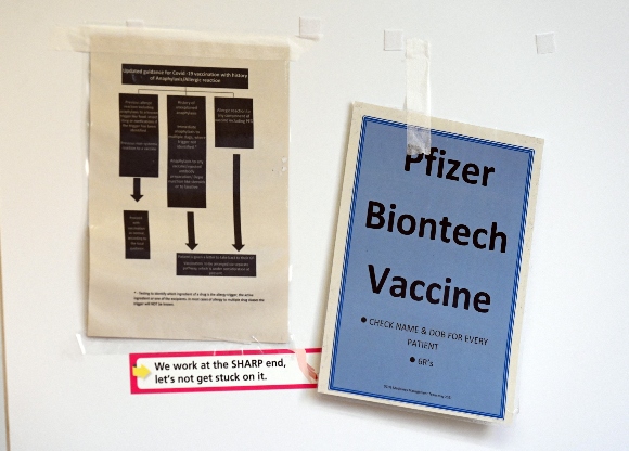 A poster reading Pfizer BioNTech Vaccine is pictured at a Covid-19 vaccination centre