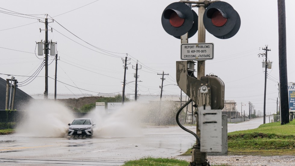 A car speeds through a flooded street ahead of the Tropical Storm Nicholas