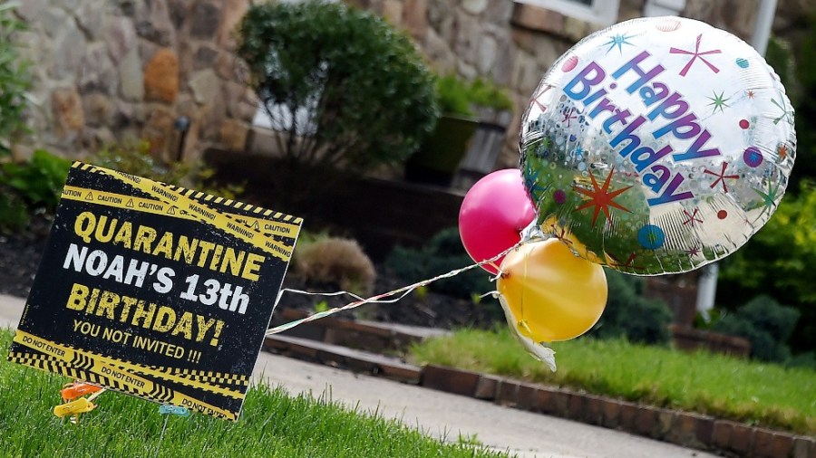 A yard sign and balloons display quarantine birthday wishes for a teen in a front yard in Arlington, Va., on April 27, 2020